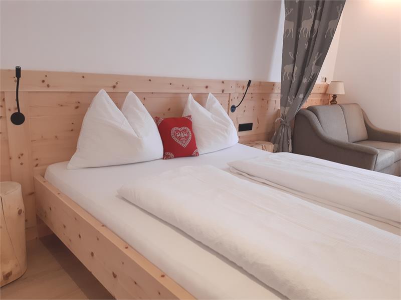 Bedroom in solid Swiss pine, pleasant atmosphere thanks to glare-free indirect lighting